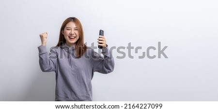 Portrait of beautiful Asian woman holding mobile phone on isolated background, portrait concept used for advertisement and signage, isolated over white background, copy space.