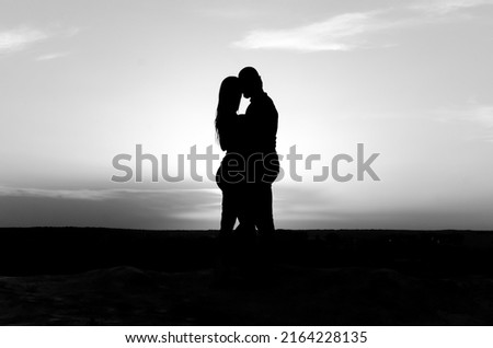 silhouette of man and woman on sky background. black and white photo