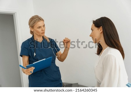 Therapist conducts a preventive examination of a woman in her office in a modern clinic