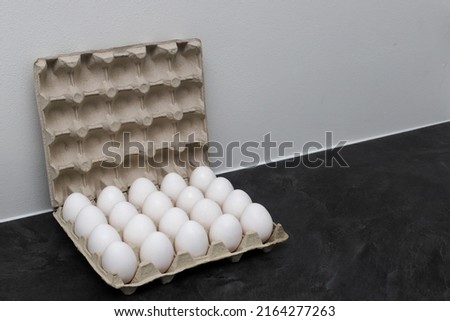 Tray with two dozen eggs. 20 eggs. tray with eggs on a gray background. Royalty-Free Stock Photo #2164277263