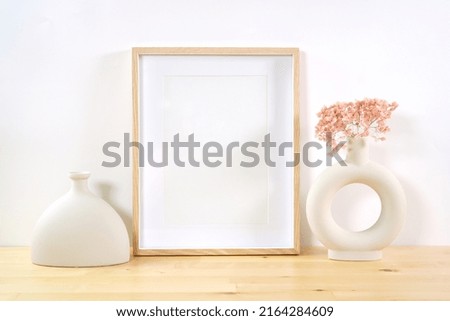 Art print vertical frame product mockup. Boho theme craft product mockup styled with Scandinavian Boho Nordic ceramic vases against a white background.