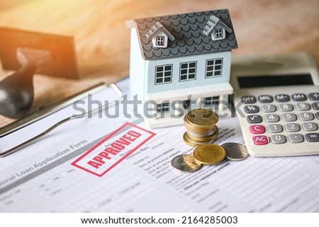 Home loan approved on loan application form paper with rubber stamp calculator coin and loan house model on table, Loan approval business finance economy commercial real estate investments concept Royalty-Free Stock Photo #2164285003