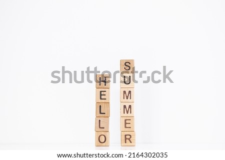 Hello summer word is written on wooden cubes on a white background. Closeup of wooden elements