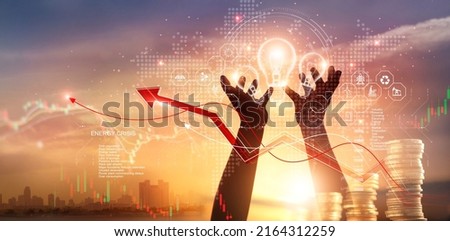 Energy crisis, Hands touch light bulb with energy resources icon and rising graph data chart representing electricity crisis, Economy and alternative energy, Sustainability. Ecological friendly. 
