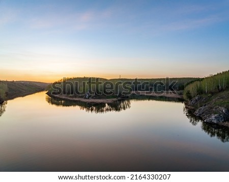 Confluence of the Iset and Kamenka rivers in the city Kamensk-Uralskiy. Iset and Kamenka rivers, Kamensk-Uralskiy, Sverdlovsk region, Ural mountains, Russia. Aerial view. Spring sunset landscape