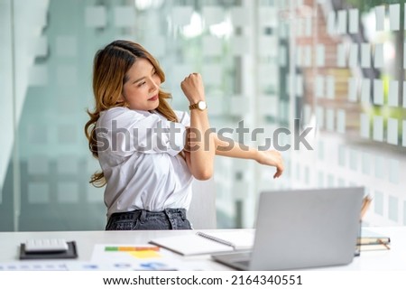 Office asian business woman stretching body for relaxing while working with laptop computer at her desk, office lifestyle, business situation Royalty-Free Stock Photo #2164340551