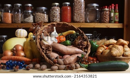 Baskets of Fresh Vegetables and Bread in Rustic Kitchen With Jars of Dried Food in Background Royalty-Free Stock Photo #2164353821