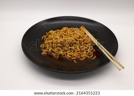 Boiled instant noodles in a black dish,Include Clipping Path.