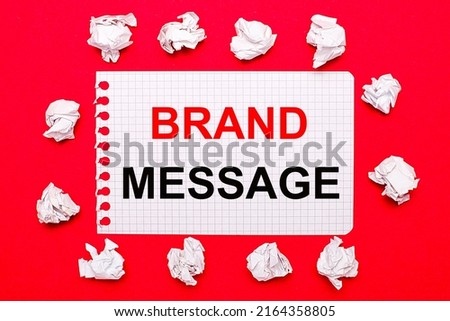 On a bright red background, white crumpled sheets of paper and a sheet of paper with the text BRAND MESSAGE