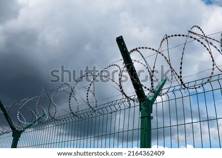 Barbed wire fence with the sky in the background.