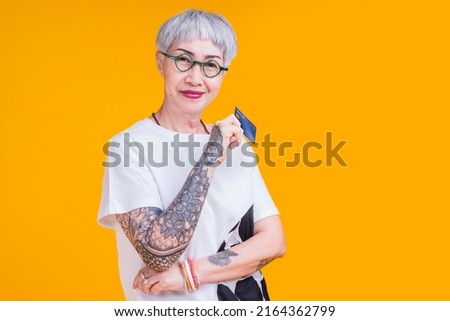 old senior asian woman tattoo hand show credit card with smile confident and cheerful studio shot,asia old woman grey hair standing hand gesture hold credit care cashless payment business ideas