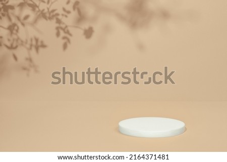 Abstract minimal nature scene - empty stage and circle podium on beige background and soft shadows of rose flowers and leaves. Pedestal for cosmetic product and packaging mockups display presentation Royalty-Free Stock Photo #2164371481
