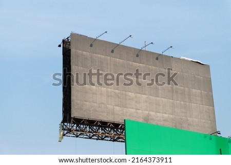 Blank billboard against blue sky for outdoor advertising poster in city.