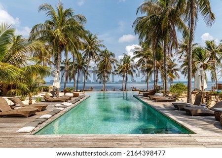 Sun loungers and umbrellas near the swimming pool. Destination holiday. Indonesia. Royalty-Free Stock Photo #2164398477