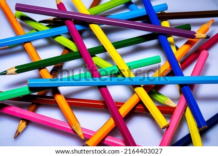 Background of colorful sharpened colored pencils on a white background. Multicolored wooden pencils close up. Stationery set for drawing, coloring. Art school, a tool for creativity.