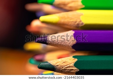 Side view of sharpened wooden colored pencils. A set of colorful multicolored drawing pencils close up. Art school, a tool for creativity.