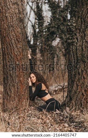 Curly girl doing yoga poses in nature