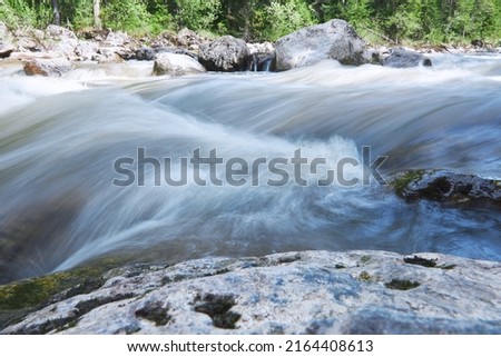 Fast water flow of a mountain river. Long exposure.