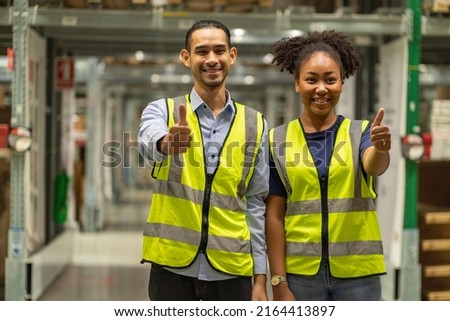 African American female employee in a warehouse with an Asian male employee thump up and service together in wholesale shop.Teamwork concept. Royalty-Free Stock Photo #2164413897
