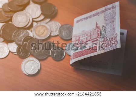 Closeup shot of Lao KIP currency and Thai baht coin, exchange and inflation concept, copy space for text wood background