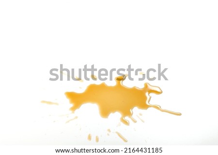 Liquid stain dirty splashing on floor. Tea or coffee stain splash on white background. Yellow brown stain of  liquid pouring on white surface Royalty-Free Stock Photo #2164431185
