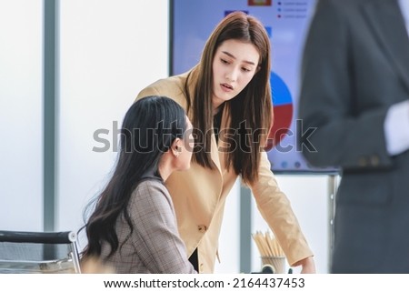 Asian young female professional successful businesswoman mentor teaching training helping supporting new recruitment employee staff learning job task online via computer in company office workstation.