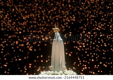 The statue of Our Lady of Fatima in front of the pilgrims at the end of the Procession of Candles in the Sanctuary of Our Lady of Fatima, Portugal Royalty-Free Stock Photo #2164448751