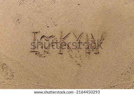 Picture of heart handwritten on sand. Sign of love on sunny outdoor background.  writing on the sand I love Kyiv. Background or texture