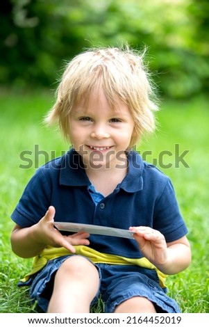 Cute toddler child, holding a picture of his little unborn baby sister from the ultrasound