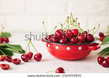 Freshly harvested cherries in a bowl. Fresh sweet organic cherries in a red bowl. Royalty-Free Stock Photo #2164459835