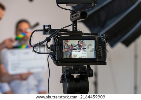 Video Camera and Video Production Studio Set. Actor, Slate Can Be Seen Through Monitor With Blurry Background Royalty-Free Stock Photo #2164459909