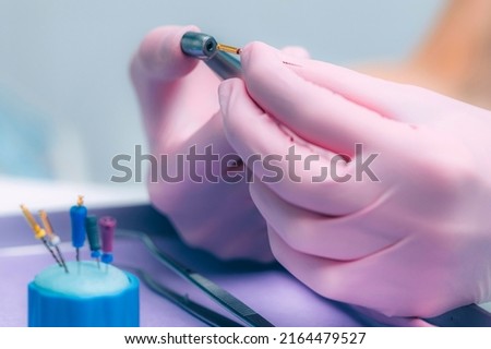 An Endodontist Holding Barbed Broach, Root Canal Treatment in Dental Clinic. Royalty-Free Stock Photo #2164479527