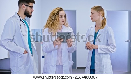 Main doctor woman and two medical students have a practice day in the hospital they analyzing the diagnostic of the patient