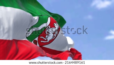 The flag of North Rhine-Westphalia waving in the wind on a clear day. North Rhine-Westphalia is the most populous state of Germany Royalty-Free Stock Photo #2164489161