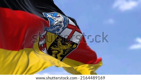 The flag of Saarland waving in the wind on a clear day. Saarland is a German state (Land) situated in southwestern Germany Royalty-Free Stock Photo #2164489169