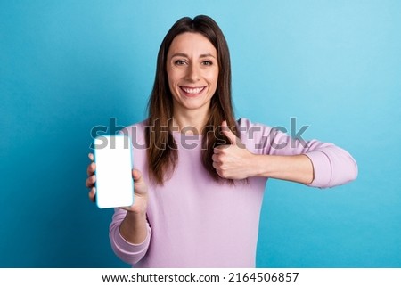 Photo of young lady present show thumb-up feedback suggest mobile device web nomad isolated over blue color background