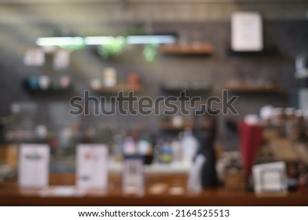 Blured background Front view of coffee shop or cafe bar restaurant nobody indoor. Empty coffee shop interior daytime with wooden design counter cement wall in background.