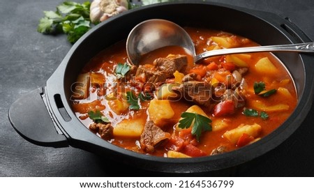 Beef goulash, soup and a stew, made of beef chuck steak, potatoes and plenty of paprika. Hungarian  traditional meal. Royalty-Free Stock Photo #2164536799