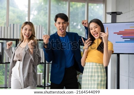 Group of Asia young entrepreneurs creative people looking at camera and excited for success project, working together in the office. Stratup business team discusses and shares ideas for new projects. Royalty-Free Stock Photo #2164544099