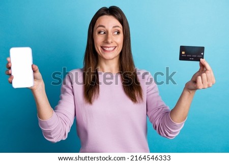 Photo of young lady hoold mobile eshop menu website credit card profit isolated over blue color background