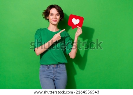 Photo of sweet shiny woman dressed summer t-shirt pointing heart like sign isolated green color background