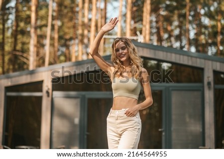 Friendly attractive lady greeting somebody by her cottage