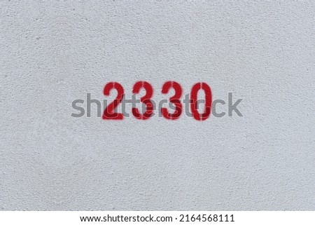Red Number 2330 on the white wall. Spray paint.
