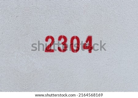 Red Number 2304 on the white wall. Spray paint.
