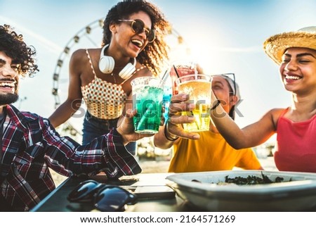 Diverse young people celebrating cheering cocktail glasses outside - Happy group of friends having fun together on summer vacation - Friendship concept with guys and girls enjoying weekend event 