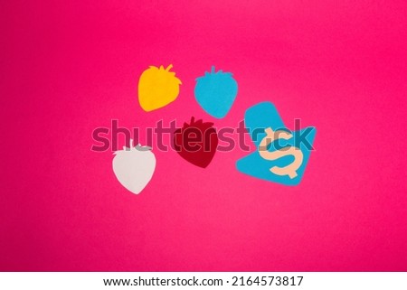 colorful strawberries on pink background, creative design falling price, abstract paper background