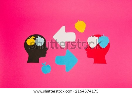 black and red paper head with a brain of fruit that symbolizes knowledge, two heads exchange knowledge and improve each other, creative art design on the pink background