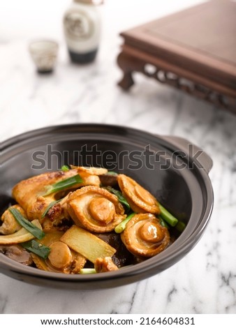 Braised Chicken and Abalone with Abalone Sauce served in Casserole served in a pot side view on grey background Royalty-Free Stock Photo #2164604831