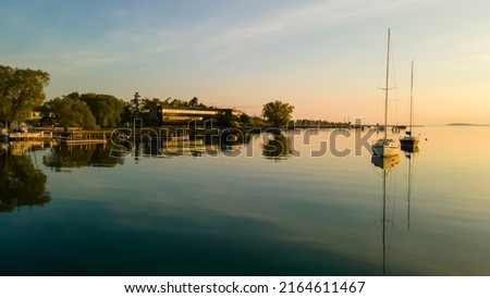 Boats anchored in still water at sunrise near Traverse City Michigan
