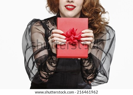 Glamorous woman holding red present box with big bow isolated on white background